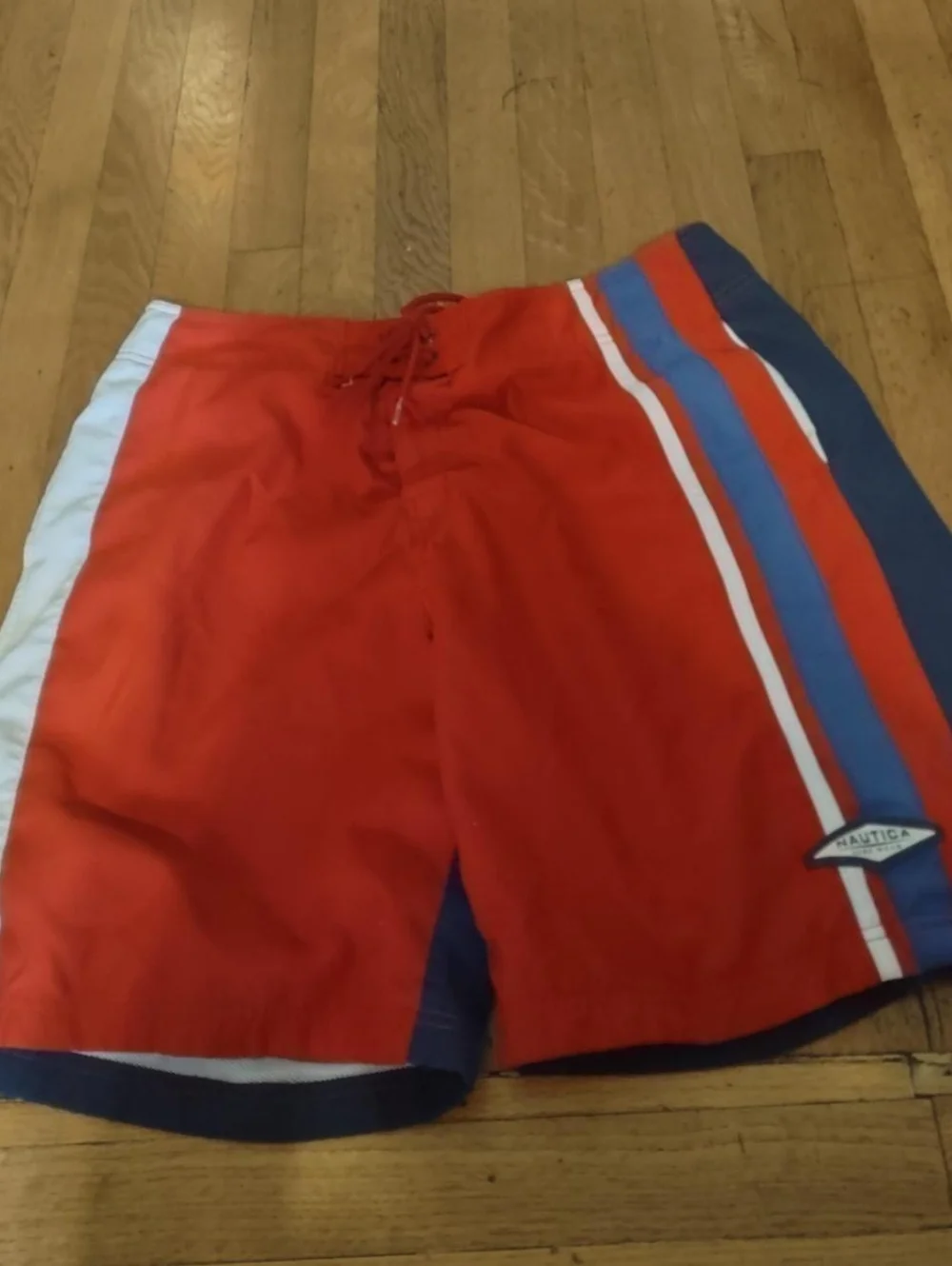 red swim trunks with navy blue back and blue and white stripes from nautica 36W